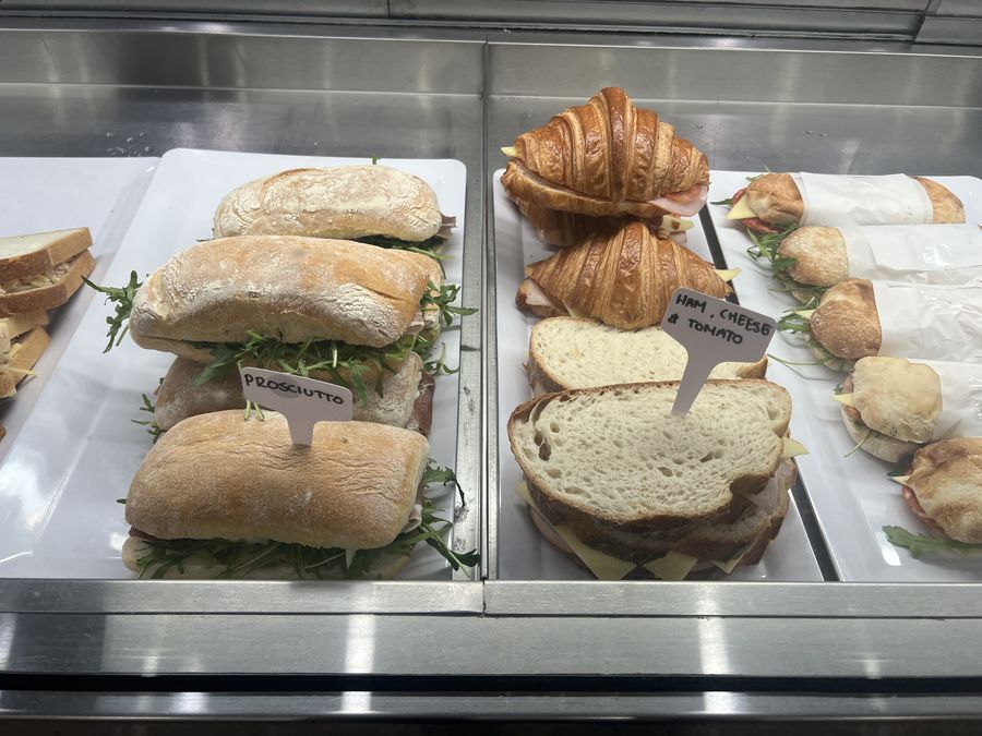 Ciabatta rolls, croissants and wrapped rolls on trays in the Harry's display counter